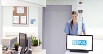 Nurse smiles as she moves NOVA MCA 30L solution from nursing station and into patient room